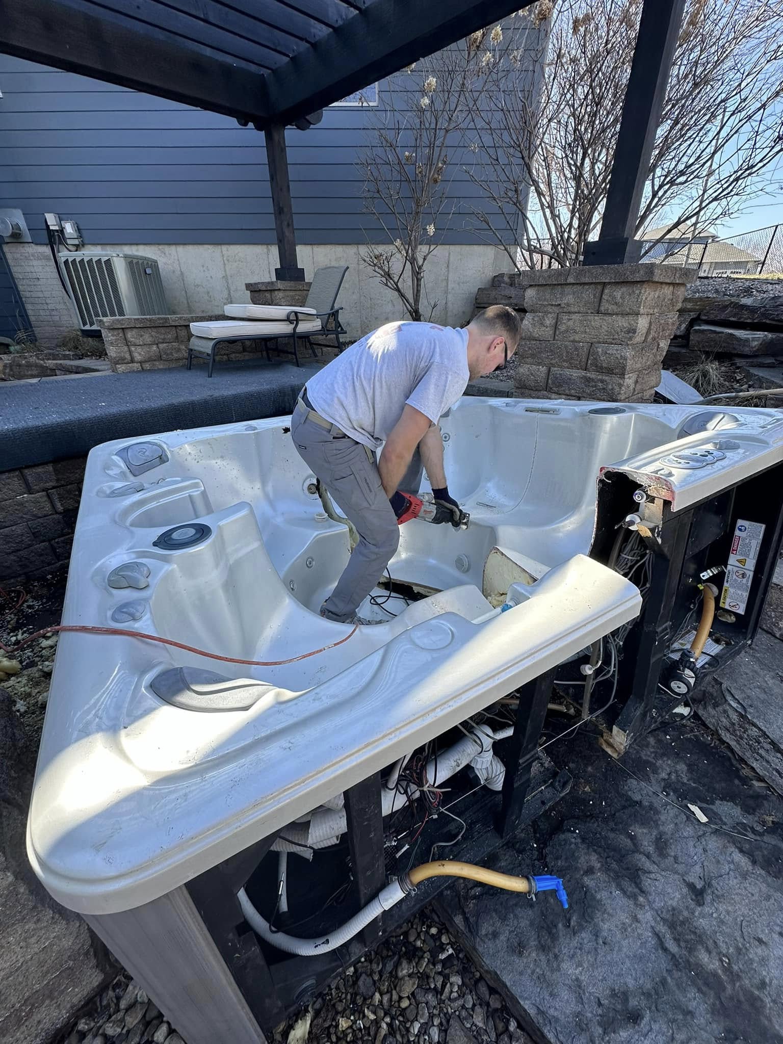 WeHaul crew dismantling an above-ground hot tub for removal in a Sioux Falls backyard