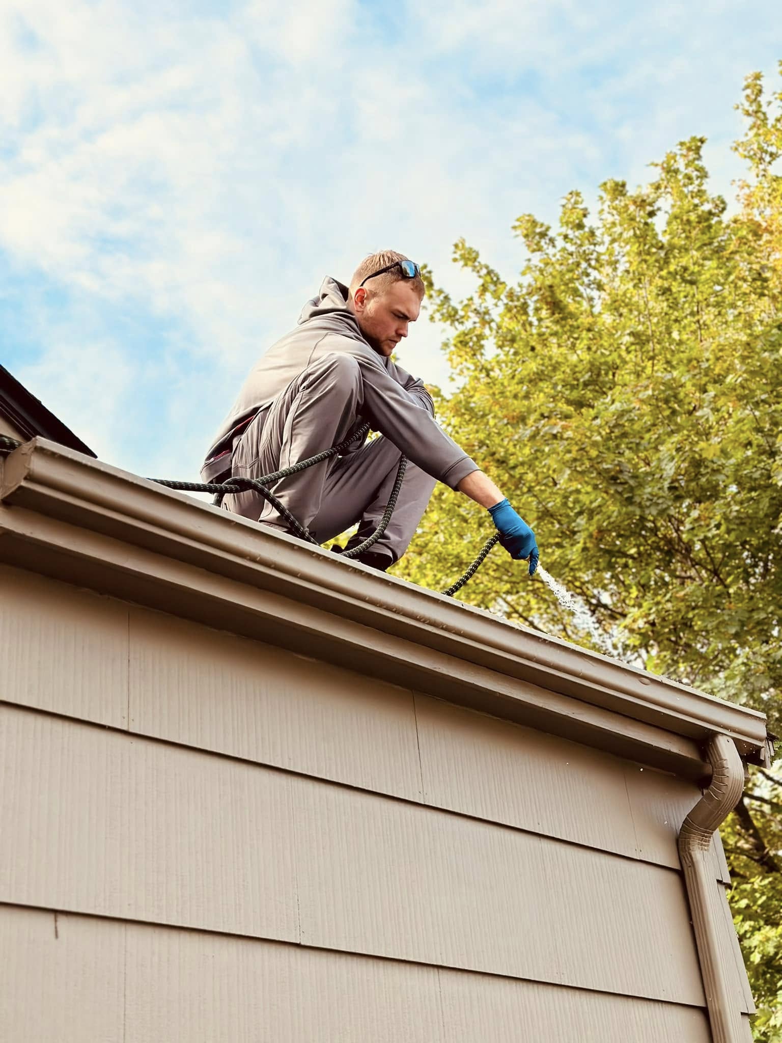 WeHaul crew member on a roof in Sioux Falls, SD — the kind of job most people would rather not climb up for