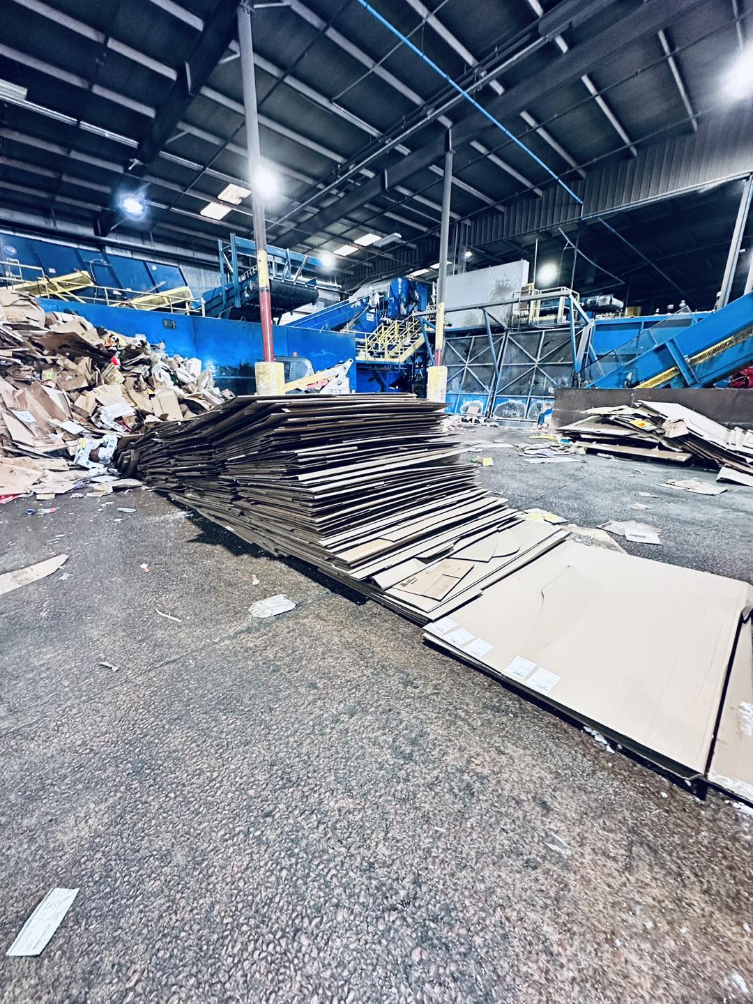 Stacks of cardboard at a recycling facility — WeHaul donates and recycles whatever it can before landfill